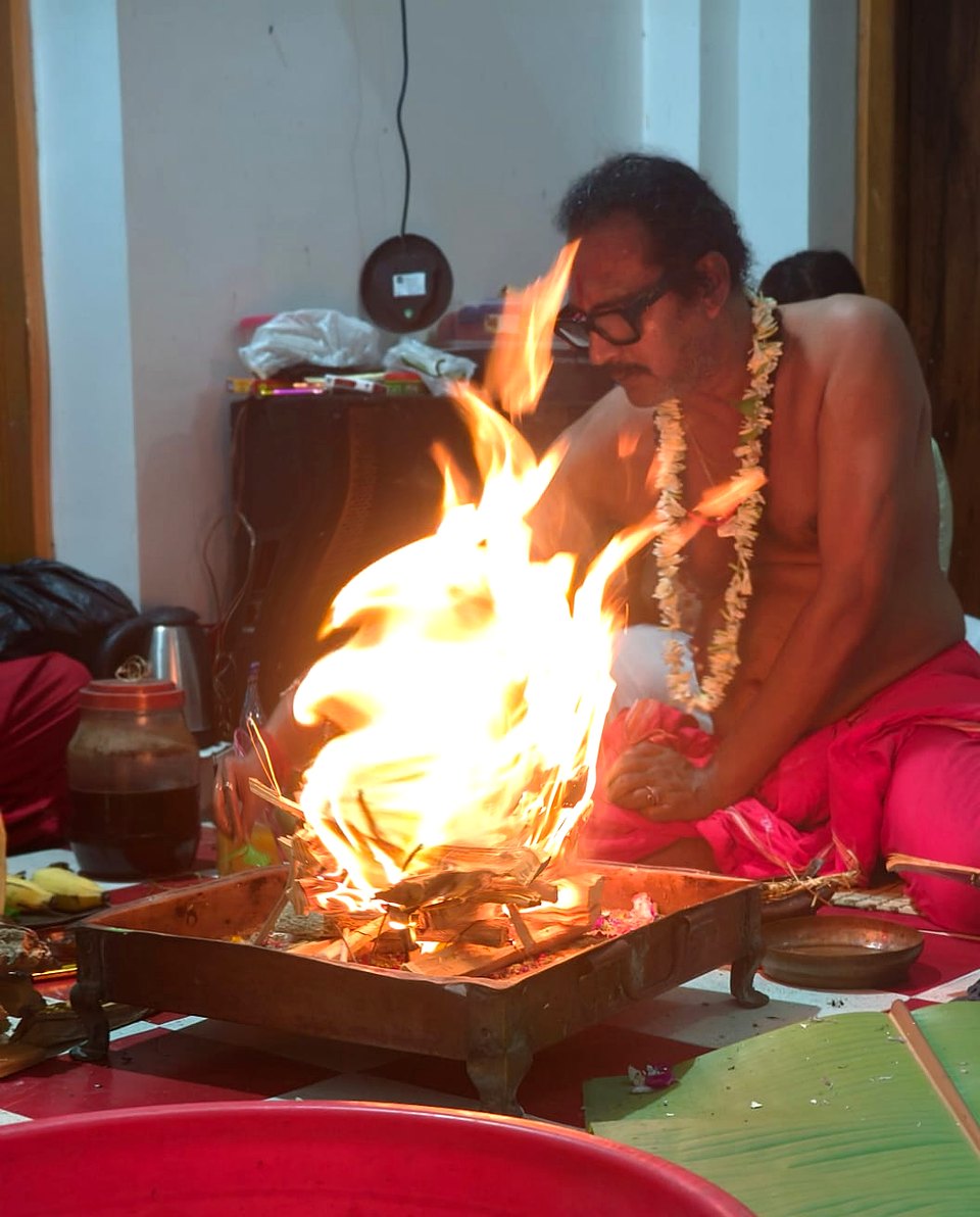 Sri Meenananda Tirthanath tending the homa fire in the shrine room.