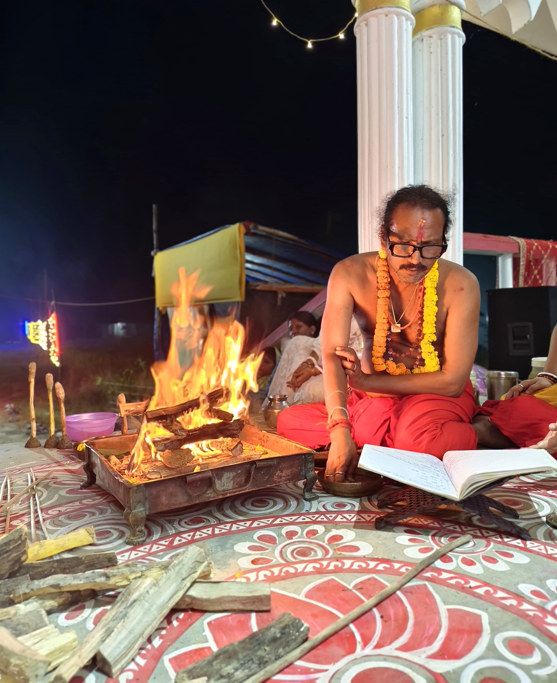 Open scripture and offerings beside the homa fire.