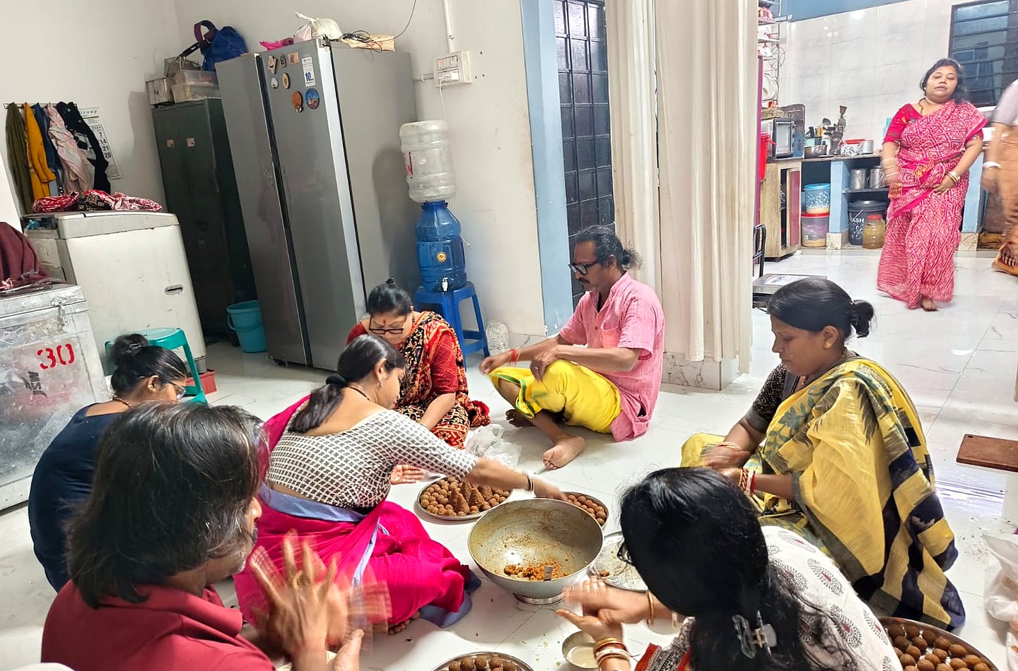 Volunteers preparing ladoo in the Ashram kitchen.