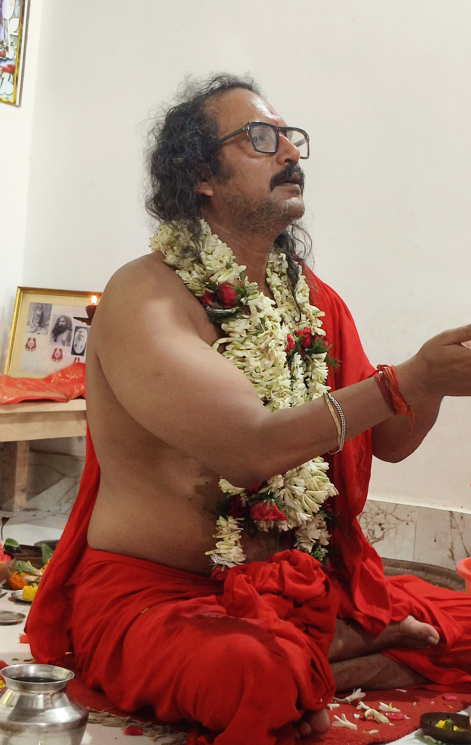 Sri Meenananda Tirthanath in seated puja, offering with joined hands.
